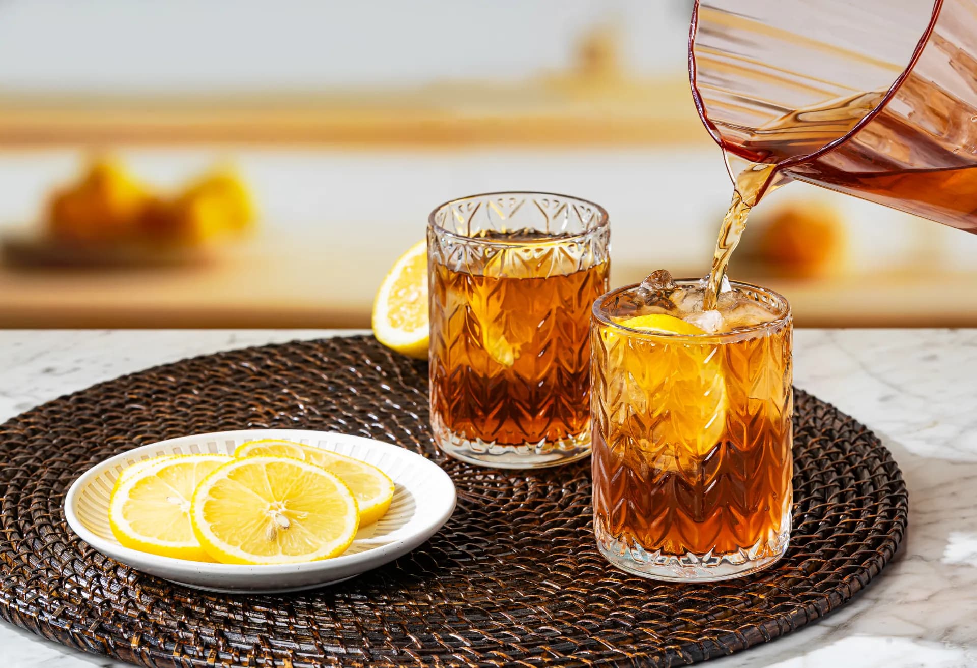 Iced tea poured over lemon and ice